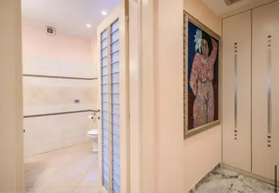a bathroom with a toilet and a painting on the wall at La Dolce Vita Of Via Veneto - Prestigious Apartment With Wonderful Terrace In the Historic Center in Rome
