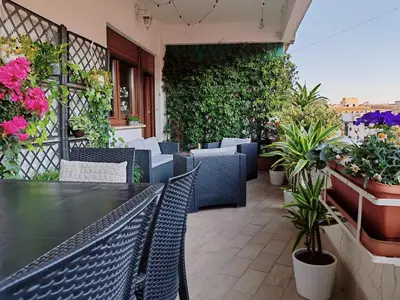 a patio with a table and chairs and plants at La Dolce Vita Of Via Veneto - Prestigious Apartment With Wonderful Terrace In the Historic Center in Rome