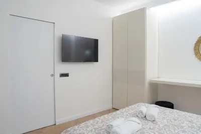 a bedroom with a bed with a tv on the wall at Maison Vaticano - A few steps from Vatican and San Peter in Rome