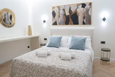 a white bedroom with a large bed with two pillows at Maison Vaticano - A few steps from Vatican and San Peter in Rome