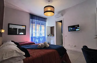 a bedroom with two beds and a table and a mirror at IAIO Testaccio Retrò in Rome