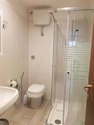 a bathroom with a toilet and a glass shower at Hotel Azzurra in Rome