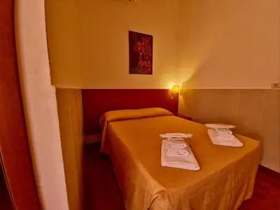 a small room with a bed with towels on it at Hotel Azzurra in Rome