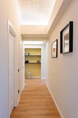 a hallway with white walls and wood floors and a ceiling at Casa Scipioni by Hili in Rome
