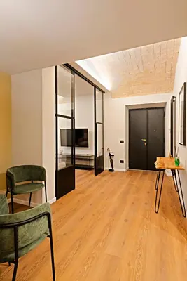 a living room with a table and chairs and a tv at Casa Scipioni by Hili in Rome
