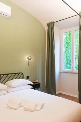 a bedroom with two beds and a window at Casa Scipioni by Hili in Rome