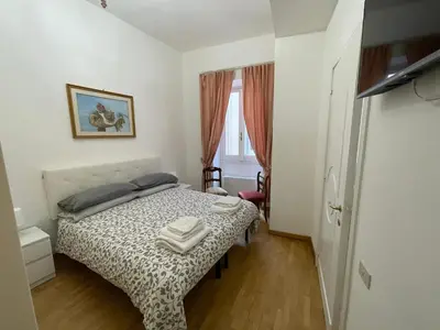 a small bedroom with a bed and a window at Charming Apartment Near Roman Forum - 60 m² in Rome