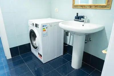 a bathroom with a washing machine and a sink at Vatican 4 BedRoom Apartment with Private Parking in Rome