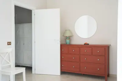 a bedroom with a red dresser and a mirror at Vatican 4 BedRoom Apartment with Private Parking in Rome