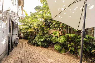 a brick alley way with plants and an umbrella at Unique Garden Apartment near Caracalla Baths in Rome