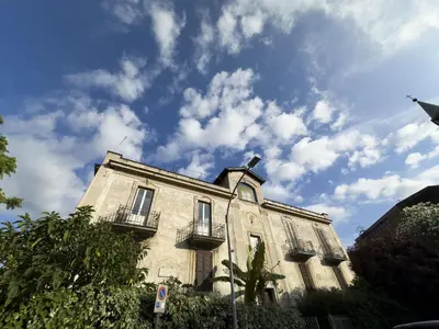 a building with balconies and a blue sky with clouds at Unique Garden Apartment near Caracalla Baths in Rome