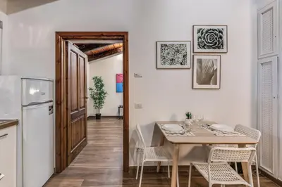 a kitchen and dining room with a table and a refrigerator at Luciana Vatican Apartment in Rome