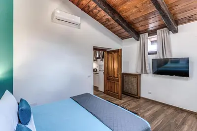 a bedroom with a bed and a flat screen tv at Luciana Vatican Apartment in Rome