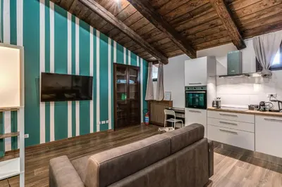a living room with a couch and a kitchen at Luciana Vatican Apartment in Rome
