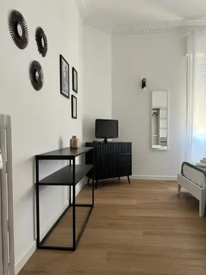 a living room with a table and a tv on a wall at Casa Palmiero in Rome
