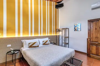 a bedroom with a bed and a striped wall at Elena Vatican Apartment in Rome