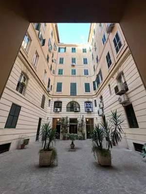 a large building with potted plants in a courtyard at Elena Vatican Apartment in Rome