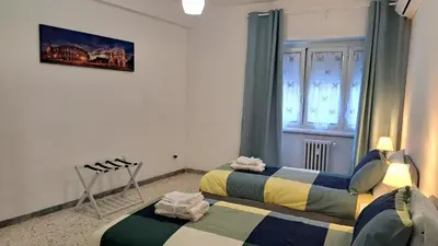 a room with two beds and a window at Roman Holidays Apartment in Rome