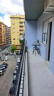 a balcony with a table on the side of a building at Roman Holidays Apartment in Rome
