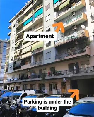 a building with parking is under the building at Roman Holidays Apartment in Rome