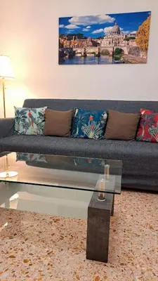 a living room with a couch and a glass table at Roman Holidays Apartment in Rome