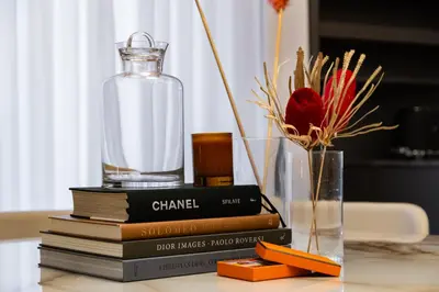a stack of books and a glass bottle on a table at BDC - Luxurylifestyle in Rome