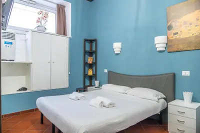 two beds in a blue room with towels on them at Lion Renting Colosseum in Rome