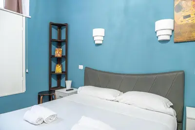 a blue bedroom with a bed with white pillows at Lion Renting Colosseum in Rome