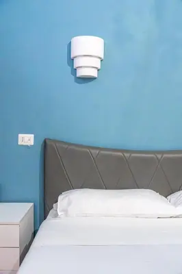 a bedroom with a bed with a blue wall at Lion Renting Colosseum in Rome
