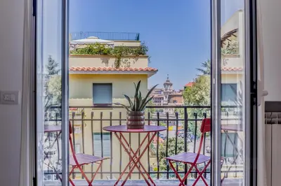 a balcony with a table and chairs and a view of a city at Domvs Domitilla in Rome