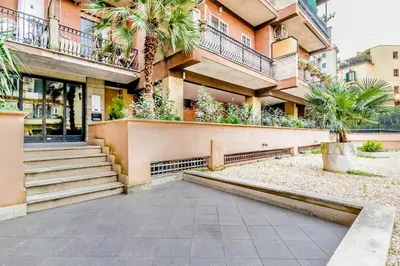 a building with stairs and palm trees in front of it at Domvs Domitilla in Rome