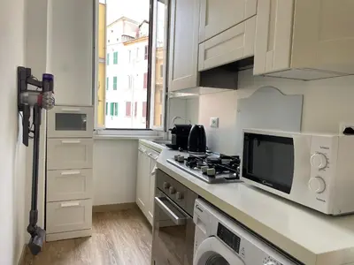 a white kitchen with a microwave and a stove at AM Apartment San Giovanni in Rome