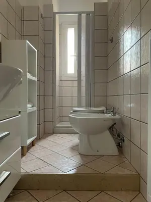a white bathroom with a toilet and a sink at AM Apartment San Giovanni in Rome