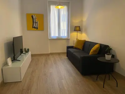 a living room with a black couch and a tv at AM Apartment San Giovanni in Rome