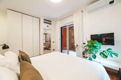 a bedroom with a white bed and a flat screen tv at Elegant Apartment Vallombrosa 55 in Rome