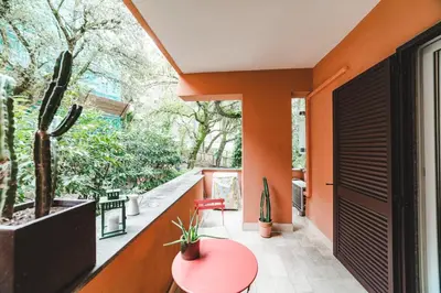 a balcony with a red table and a cactus at Elegant Apartment Vallombrosa 55 in Rome
