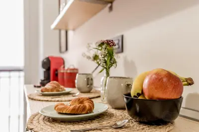 a kitchen counter with croissants and fruit on a table at Inventori House in Rome