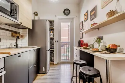 a kitchen with a refrigerator and two bar stools at Inventori House in Rome