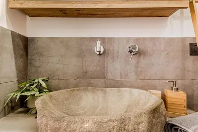 a bathroom with a large stone tub in a room at Inventori House in Rome