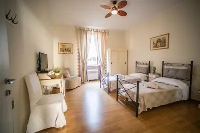 a bedroom with two beds and a ceiling fan at Rione Monti Home in Rome