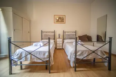 two beds in a room with wooden floors at Rione Monti Home in Rome
