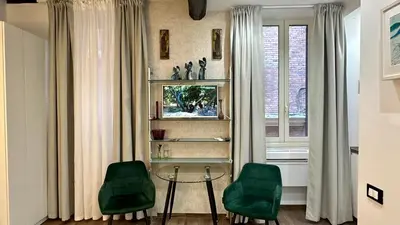 a living room with a glass table and two green chairs at Colosseo Design Apartament in Rome
