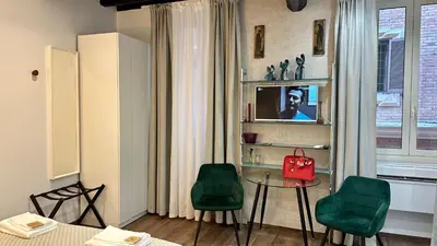 a living room with a table and two green chairs at Colosseo Design Apartament in Rome