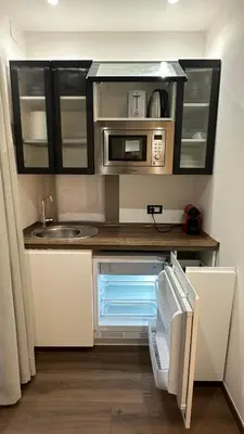 a small kitchen with a sink and a microwave at Colosseo Design Apartament in Rome