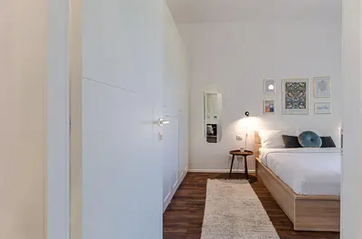 a white bedroom with a bed and a table at Domus Campi Flegrei in Rome