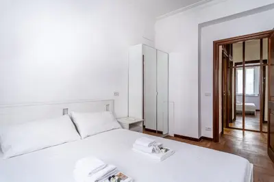 a bedroom with a white bed with two towels on it at iFlat Vatican Spacious Apartment with Terrace in Rome
