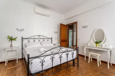 a bedroom with a large bed and a mirror at iFlat Vatican Spacious Apartment with Terrace in Rome