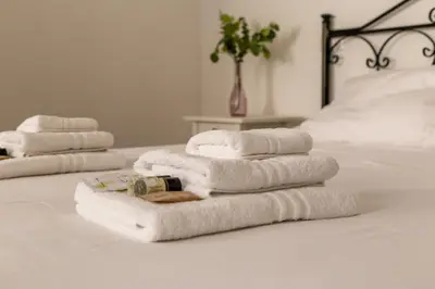 three towels are stacked on a bed at iFlat Vatican Spacious Apartment with Terrace in Rome