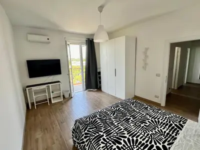 a bedroom with a black and white bed and a television at Il Cielo Su Roma San Paolo in Rome