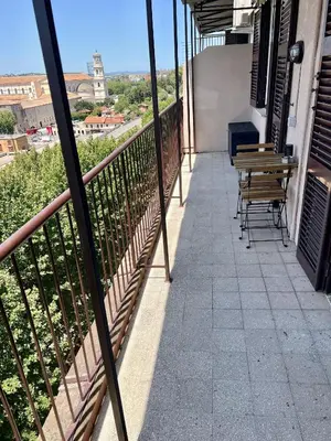 a balcony with tables and chairs on a building at Il Cielo Su Roma San Paolo in Rome
